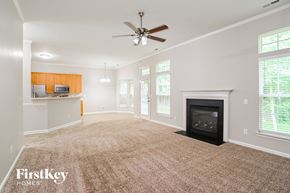 Indian Trail house for rent - A spacious living room with a fireplace and a ceiling fan.