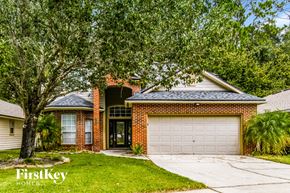 Fleming Island house for rent - a brick house with a white garage door and a tree