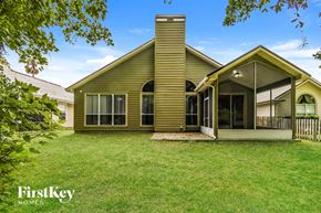 Fleming Island house for rent - a yellow house with a porch and a grass yard