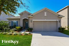 Haines City house for rent - A house with a blue door and a garage is for sale.