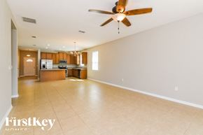 Haines City house for rent - A spacious living room with a ceiling fan and tiled flooring.