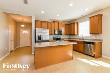 Haines City house for rent - A kitchen with wooden cabinets and a refrigerator.