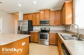 Haines City house for rent - A kitchen with wooden cabinets and stainless steel appliances.