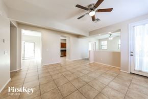 Phoenix house for rent - an empty living room with a ceiling fan and tiled floors