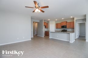 San Tan Valley house for rent - A spacious room with a ceiling fan and a kitchen area in the background.
