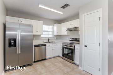 Jacksonville house for rent - A kitchen with a refrigerator, sink, oven, and cabinets.