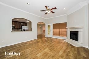 Denton house for rent - A spacious living room with a fireplace and wooden flooring.