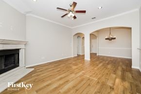 Denton house for rent - A spacious room with a fireplace and a ceiling fan.