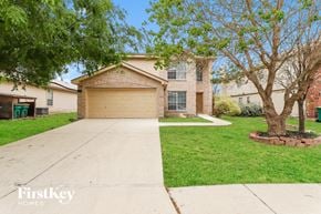 Converse house for rent - a beige brick house with a driveway and trees