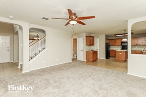 Converse house for rent - an empty living room with a ceiling fan and a kitchen