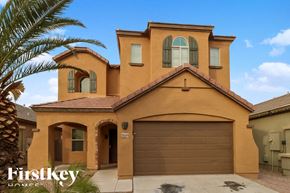 Phoenix house for rent - A house with a brown garage door and a palm tree in front.