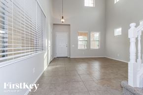 Phoenix house for rent - A spacious room with a white door and a staircase on the right.