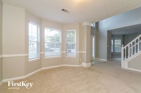 Stockbridge house for rent - an empty living room with three windows and a staircase
