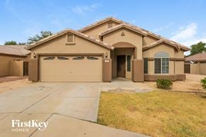Phoenix house for rent - A beige house with a brown roof and a garage door.