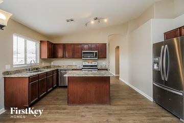 Phoenix house for rent - A kitchen with wooden cabinets and a stainless steel refrigerator.