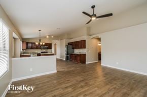 Phoenix house for rent - A spacious living room with a ceiling fan and hardwood floors.