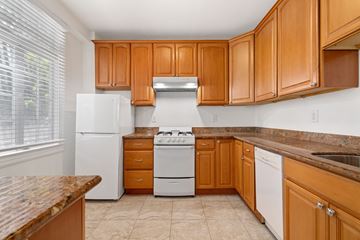 San Francisco apartment for rent - A kitchen with wooden cabinets and a white refrigerator.