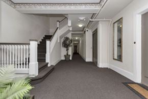 San Francisco apartment for rent - A long hallway with a staircase on the left and a door on the right.