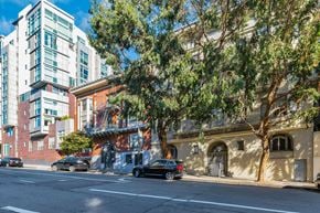 San Francisco apartment for rent - A tree in front of a building with a car parked on the side of the road.