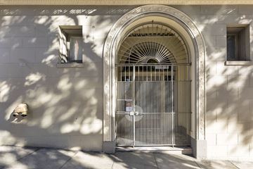 San Francisco apartment for rent - A white building with a large arched doorway and a metal gate.