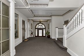 San Francisco apartment for rent - A long hallway with a staircase on the right and a door on the left.