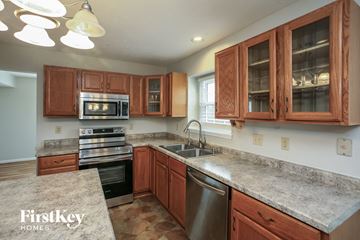 Fishers house for rent - A kitchen with wooden cabinets and granite countertops.