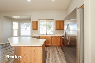 Avondale house for rent - a kitchen with wooden cabinets and stainless steel appliances and a white counter top