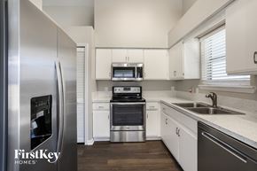 Jacksonville house for rent - a kitchen with white cabinets and stainless steel appliances