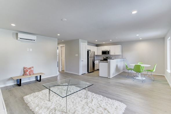 Houston apartment for rent - A modern kitchen with a glass table and white walls.