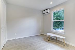 Houston apartment for rent - A room with a window, a bench, and an air conditioner.