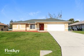 North Port house for rent - a beige house with a driveway and a lawn