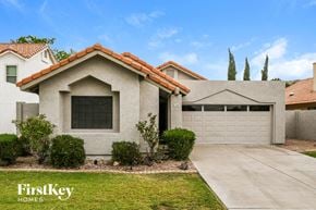 Gilbert house for rent - A house with a red tile roof and a garage door.