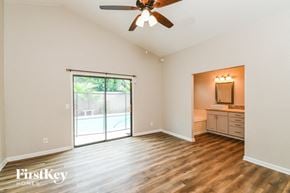 Gilbert house for rent - A spacious room with a ceiling fan and sliding glass doors leading to a backyard.