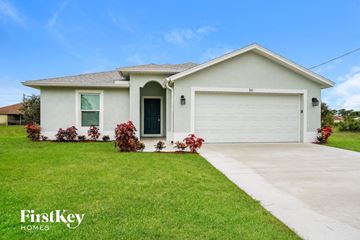 Lehigh Acres house for rent - a white house with a lawn and a driveway