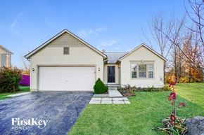 Reynoldsburg house for rent - a white house with a white garage door on a green lawn
