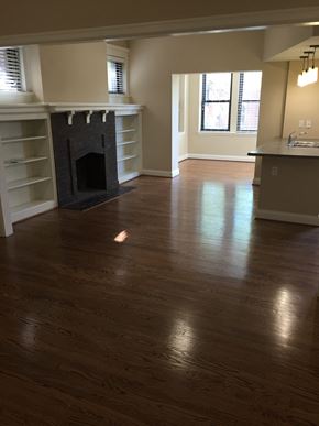 St. Louis apartment for rent - an empty living room with a fireplace and wooden floors