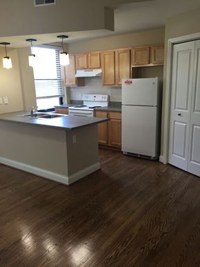 St. Louis apartment for rent - an empty kitchen with wooden floors and a refrigerator