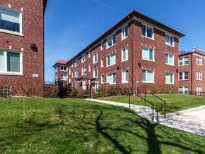 St. Louis apartment for rent - A red brick building with a green lawn in front.