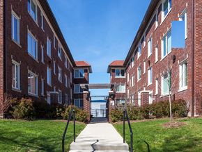 St. Louis apartment for rent - A red brick building with a walkway leading to a gate.