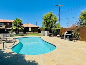Bermuda Dunes apartment for rent - A pool in a backyard with a patio and a fence.