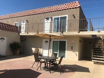 Cathedral City apartment for rent - the outside of the house with a table and chairs and an umbrella