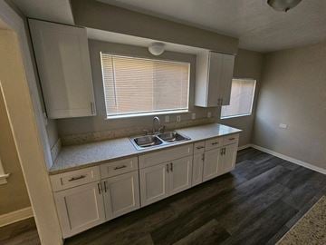Whittier apartment for rent - a kitchen with white cabinets and a sink and a window