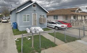 San Bernardino apartment for rent - A blue house with a red car parked in front.