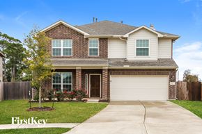 Baytown house for rent - A house with a garage and a tree in front of it.
