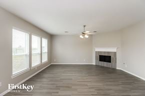 Baytown house for rent - A spacious living room with a fireplace and a ceiling fan.