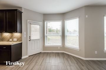Baytown house for rent - A kitchen with dark brown cabinets and a black countertop.