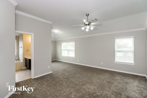 Baytown house for rent - A spacious room with a ceiling fan and carpeted floor.