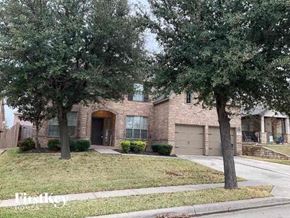 Fort Worth house for rent - A house with a brown brick exterior and a large tree in front.
