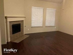 Fort Worth house for rent - A room with a fireplace and wooden floors.