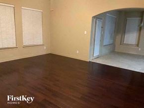 Fort Worth house for rent - A room with wooden floors and a FirstKey Homes logo.
